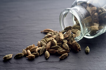 Cardamom sprinkled from a glass jar.