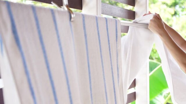 asian woman hang cloth after washed. house work concept.