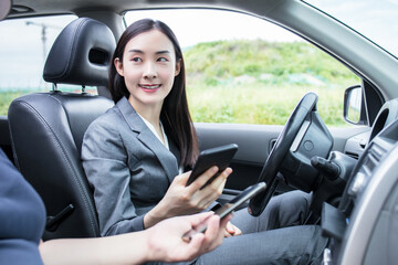 Fototapeta na wymiar Close-up Of Woman Sitting Inside Car Typing Text Message On Mobile Phone