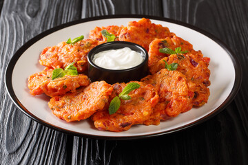 Delicious Greek tomato fritters with feta and mint served with yogurt close up in a dish on the table. horizontal