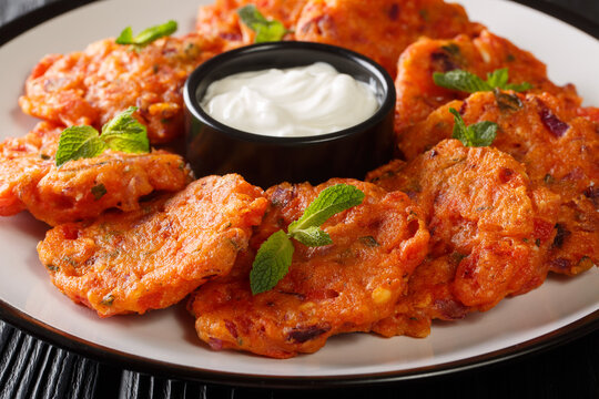 Tomatokeftedes are fried tomato balls served as an appetizer on the Greek island of Santorini close-up in a plate on the table. Horizontal
