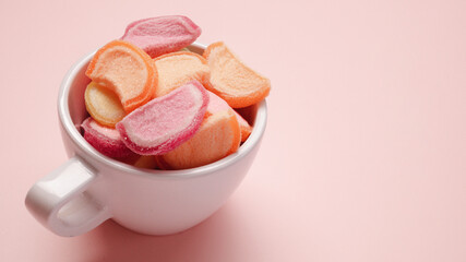 dessert fruit jelly candy in cup on color pastel two tone background copy space
