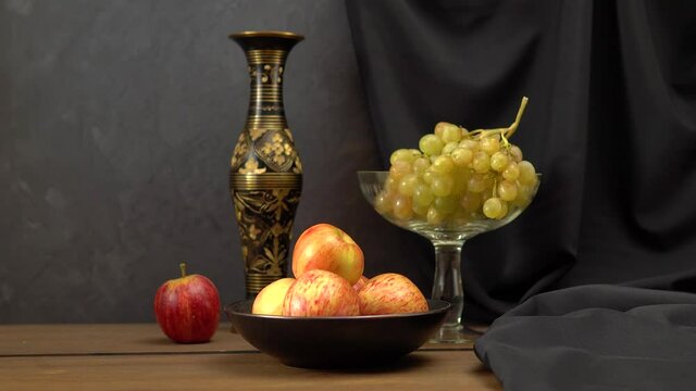 Still life with apples and grapes on a dark background