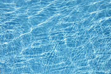 Blue water in pool with mosaic tiles at bottom. Water filter pool cleaning concept.