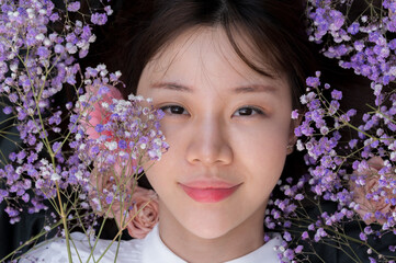 Fototapeta premium A young woman lay down in flowers.