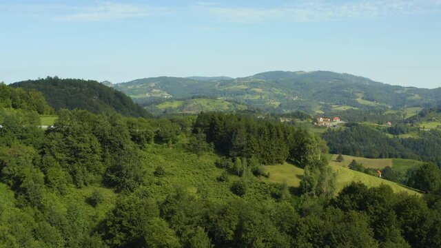 Aerial shot Serbia. drone flight in the mountains where you can see a small house surrounded by fields, forest, mountain peaks and beautiful landscape.