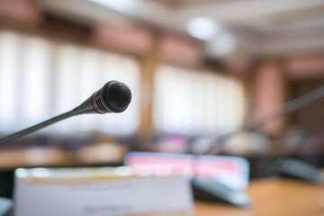 Front Microphone on abstract conference hall prepare for speaker on stage in seminar room, Business meeting and education in teaching classroom or Event light convention hall Background.