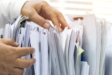 Office workers arranging stacks of lot documents report papers waiting be managed on desk in busy office. Concept of workload in business finacial paperwork information planing - obrazy, fototapety, plakaty