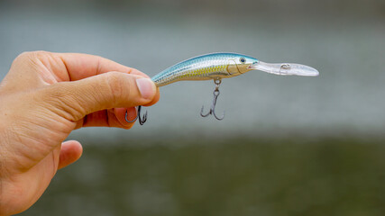fishing lure held in hand,a fishing lure is a type of artificial fishing bait used to attract fish....