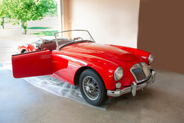 classic red antique sports car in a garage