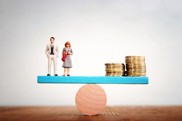 Concept image of married couple balancing stack of coins on seesaw