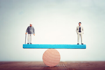 Concept of senior anf young man balancing on seesaw. Idea of age difference and planning for the future
