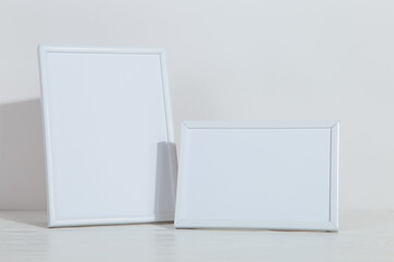 Photo frame on the table. Light stylish background. Preparation for inscriptions, copy space.