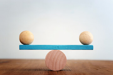 Concept of finding the right balance. Wooden balls on seesaw