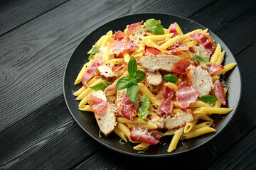 Chicken, bacon Penne pasta with parmesan cheese and basil. healthy food.