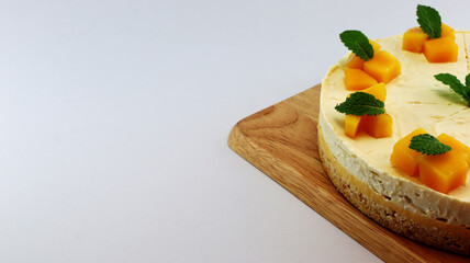 Mango cheesecake decorated with mango pulp and mint leaves