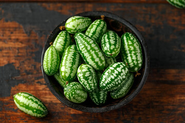 Freshly picked Cucamelon in rustic bowl on wooden table