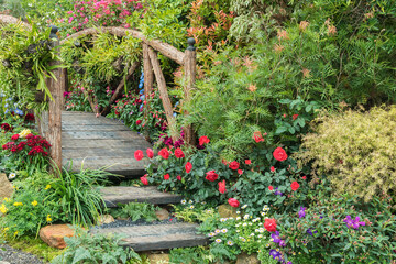 Old wooden bridge in beautiful flower garden in springtime season