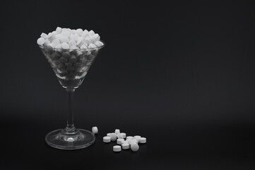 カクテルグラスからあふれた怪しい白い錠剤