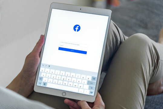 Uzhgorod, Ukraine - September 6, 2020: Woman Hands Using IPad With Facebook Homepage On Screen. Facebook The Biggest Social Network Website.