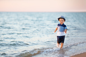 Fototapeta na wymiar little boy running on the sea beach