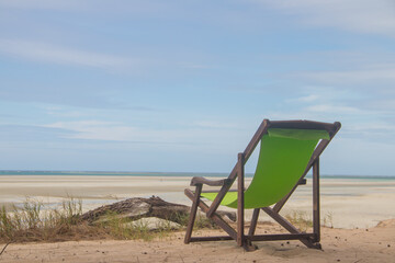 Lonely deckchair at tropical beach in time of low tide, a place to relax. Mecufi Beach, Mozambique