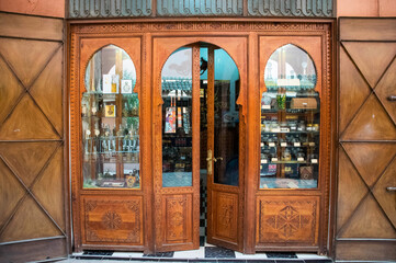 Front of a shop in the old medina of marrakech. Moroccan little store with wooden front door. Arch entrance shop. Exterior vintage architecture.