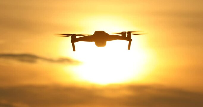 A silhouette Quadrocopter flies at sunset.sunset, drone in the sunset sky,A drone taking pictures of aerial views