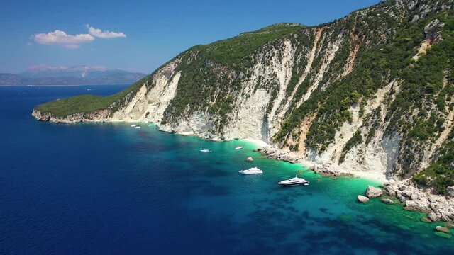 Aerial drone video of tropical paradise island covered in pine trees with turquoise crystal clear beach in Mediterranean destination