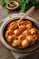 Meatballs in a pan in sweet and sour tomato sauce
