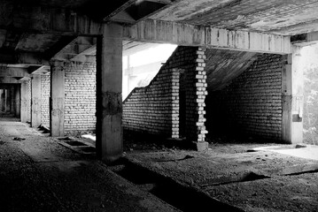 Unfinished and abandoned concrete and brick building. Unfinished construction with harsh sun light...