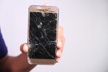 Close up of man hand holding broken smart phone.