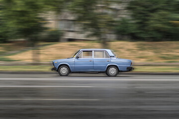 Compact blue sedan car VAZ-2101 "Zhiguli" is in motion with motion blur.
