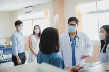 The doctor and medical nurse staff are consulting and discussing for disease of dangerouse contagious patient at the healthcare hospital by wearing face mask and stethoscope