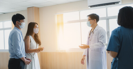 Fototapeta premium The doctor and medical nurse staff are consulting and discussing for disease of dangerouse contagious patient at the healthcare hospital by wearing face mask and stethoscope