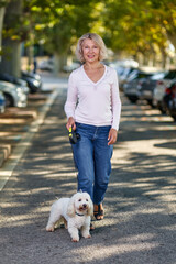 Elderly woman walking with a dog outdoors