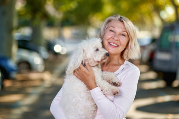 Elderly woman walking with a dog outdoors