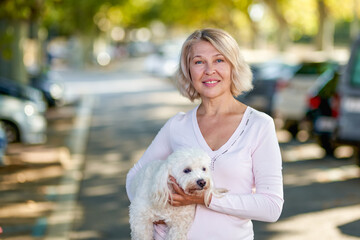 Elderly woman walking with a dog outdoors