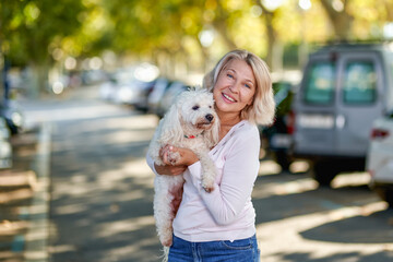 Elderly woman walking with a dog outdoors