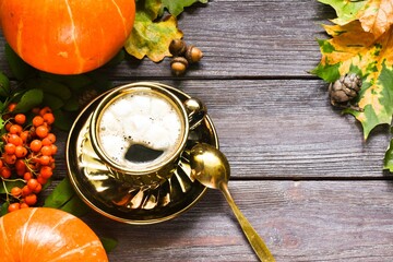 Autumn composition with cup of pumpkin latte with marshmallow,  leaves and pumpkin on wooden...