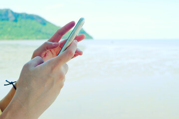 Hand holding smartphone for surfing internet and playing program.Close up.