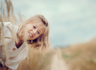 girl in a field. The child is smiling. Summer Holidays