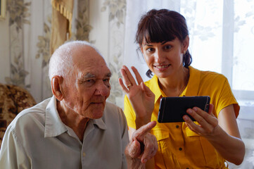 A younger man and a young woman communicate with their relatives via the phone. using smartphone...