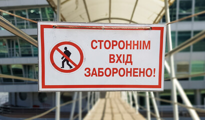 Warning sign No unauthorized entry written in red text in Ukrainian on a white rectangular table. The sign prohibits the passage of strangers.
