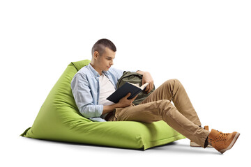 Guy sitting on a green bean bag chair and reading a book