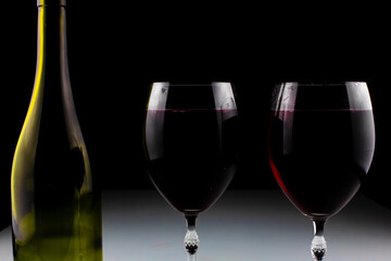 wine bottle and glass on black background