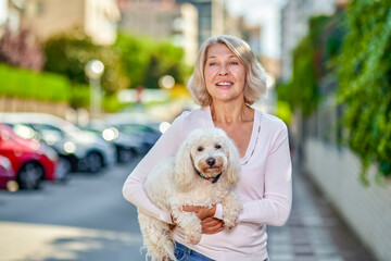 woman with a dog in her arms on a city street