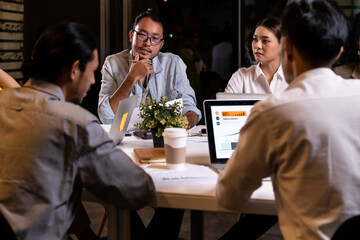 Working late, interracial asian business team brainstorm idea meeting.