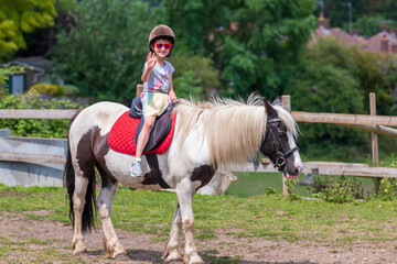 Horseback riding, lovely equestrian - young girl is riding a horse