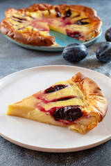 Clafoutis with plums is a French dessert that combines features of a casserole and pie. Fruits in a sweet pancake-like egg batter are baked in casserole dishes.